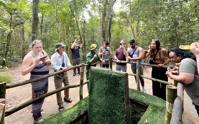 Visitors observing booby trap demonstration at Cu Chi Tunnels, Vietnam.
