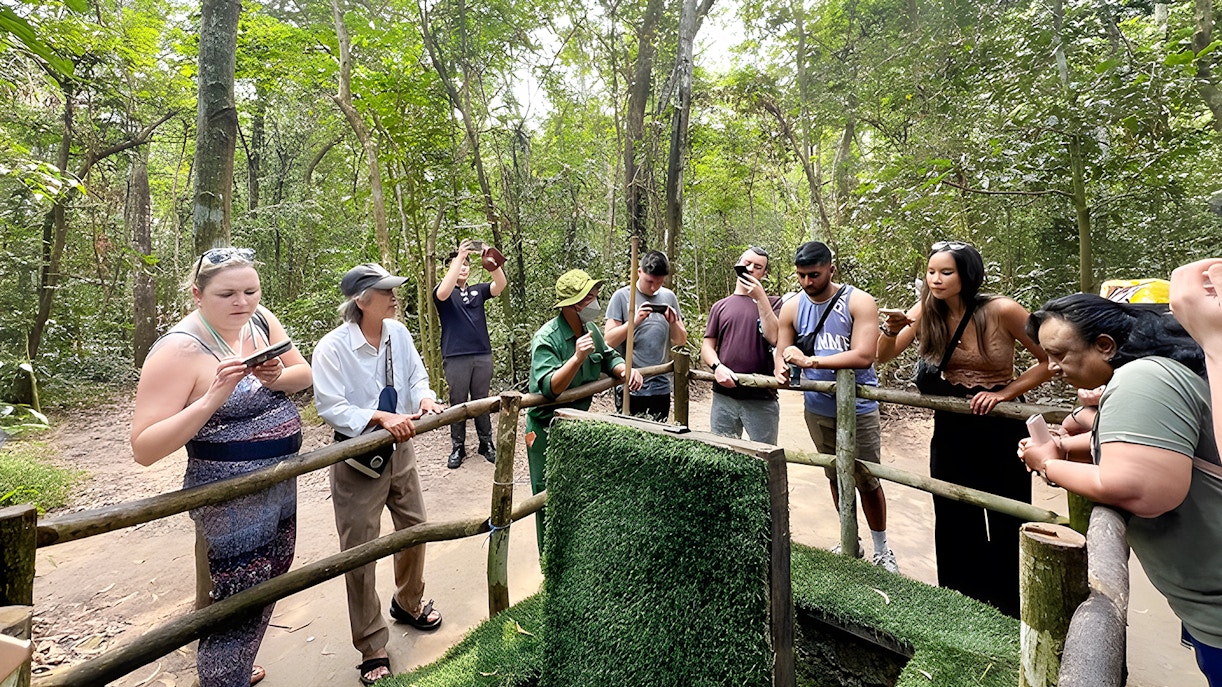 Visitors observing booby trap demonstration at Cu Chi Tunnels, Ho Chi Minh City.