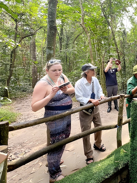 Visitors observing booby trap demonstration at Cu Chi Tunnels, Vietnam.
