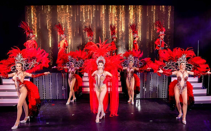 Performers in vibrant costumes on stage at Simon Cabaret Show, Phuket.