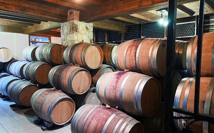 Rustic wine cellar in Cyprus with wooden barrels for vineyard tours.