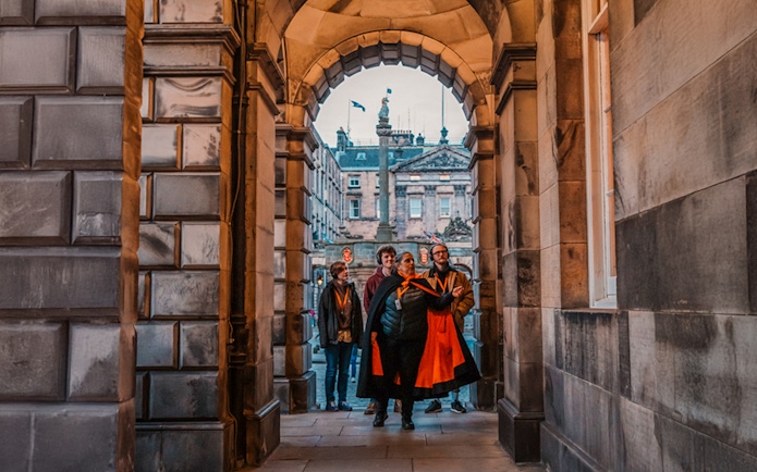 Group on guided tour under archway in Edinburgh Old Town.