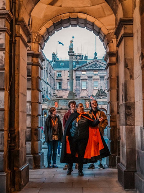Group on guided tour under archway in Edinburgh Old Town.