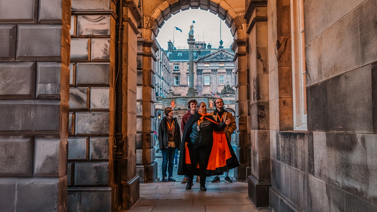 Group on guided tour under archway in Edinburgh Old Town.