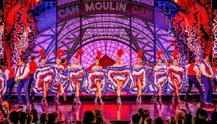 Cabaret dancers performing at Moulin Rouge in Paris with vibrant costumes.