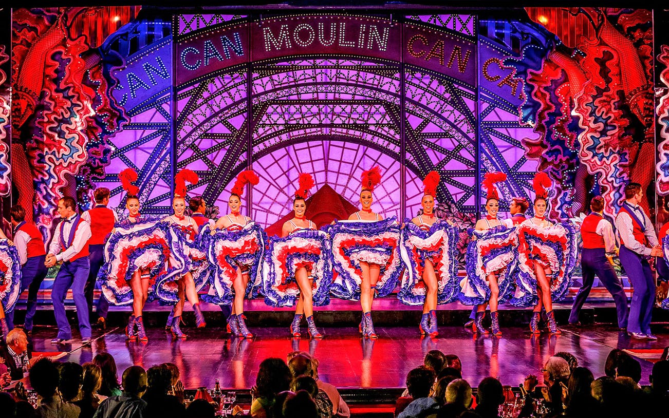 Cabaret dancers performing at Moulin Rouge in Paris with vibrant costumes.