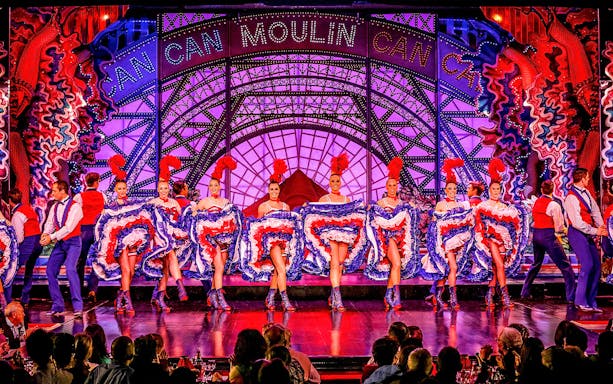 Cabaret dancers performing at Moulin Rouge in Paris with vibrant costumes.