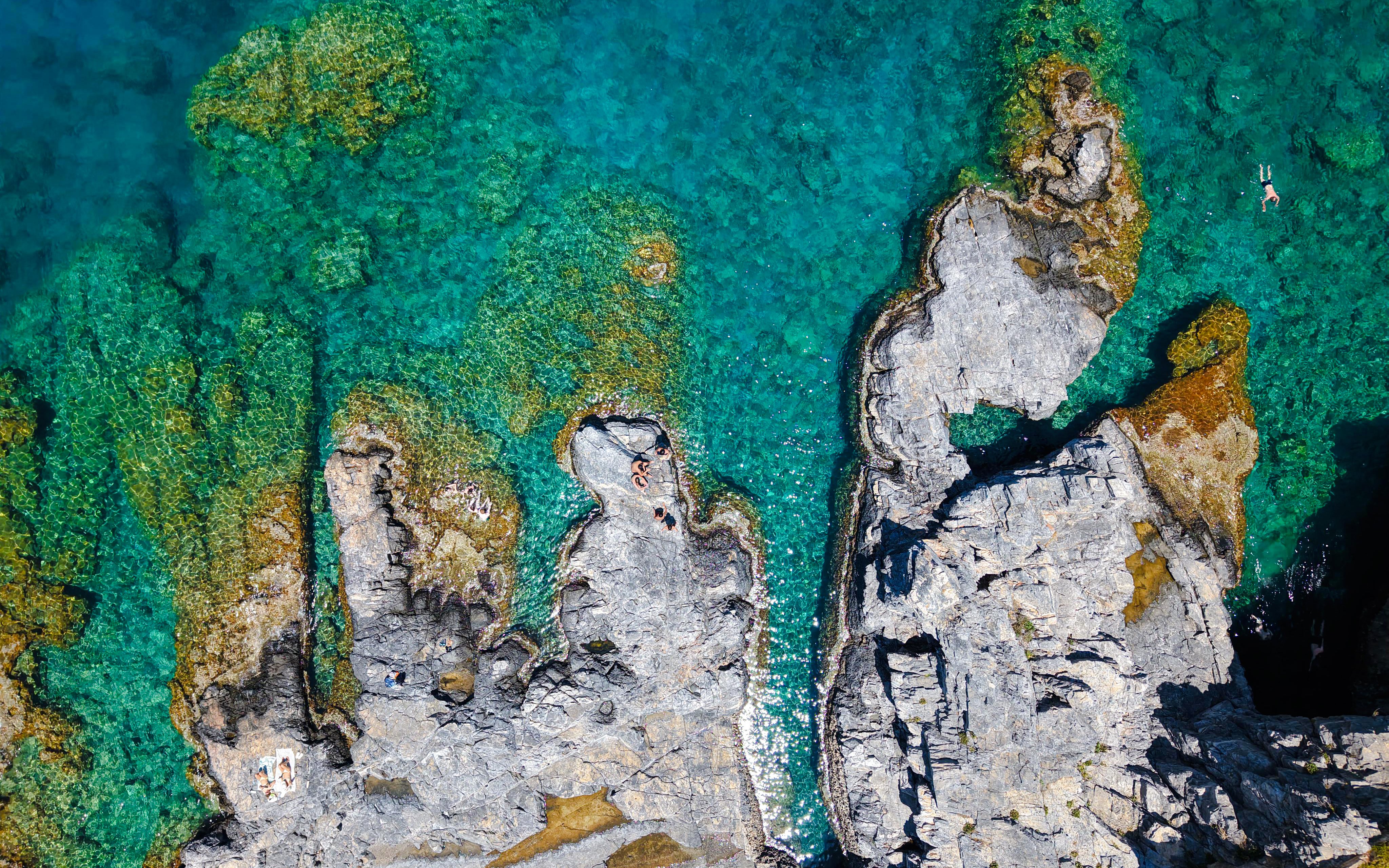 Rocky coastline with clear turquoise water, Rhodes cruise.