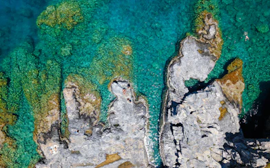Rocky coastline with clear turquoise water, Rhodes cruise.