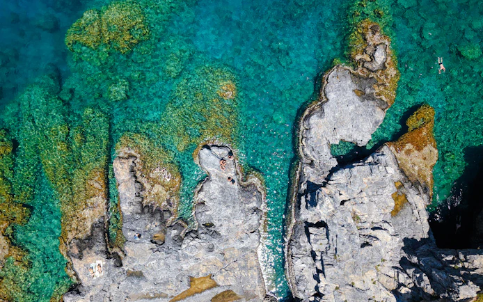 Rocky coastline with clear turquoise water, Rhodes cruise.