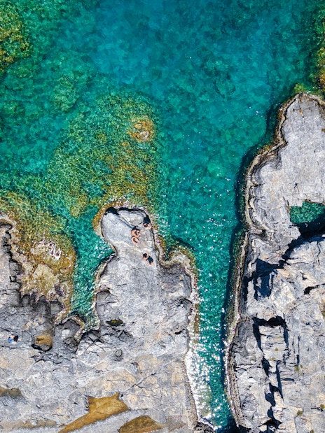 Rocky coastline with clear turquoise water, Rhodes cruise.