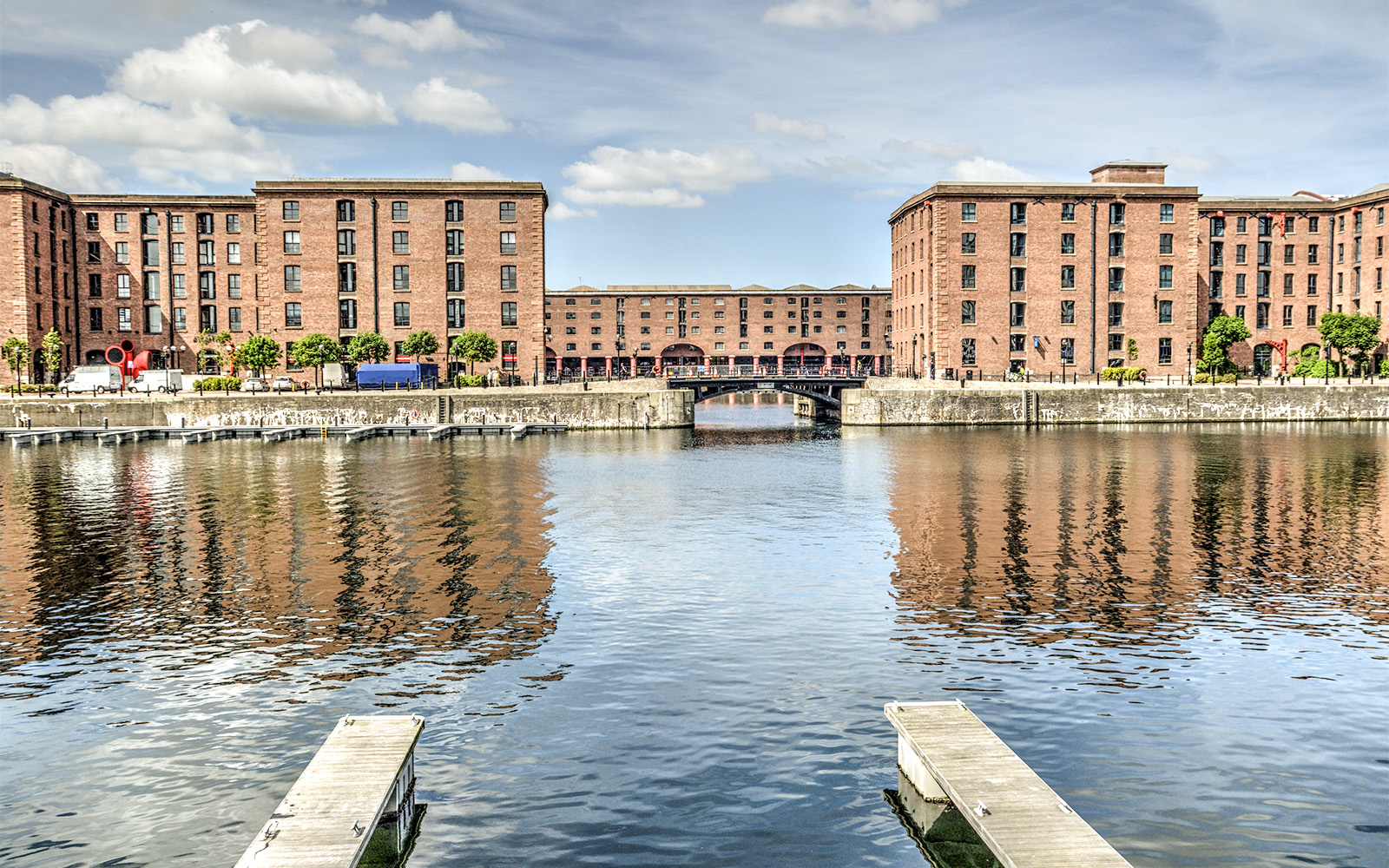 Historic dock buildings reflected in water near Museum of London Docklands.