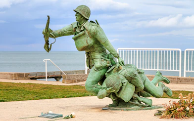 116th Regimental Combat Team Memorial statue in Normandy, France, near the sea.