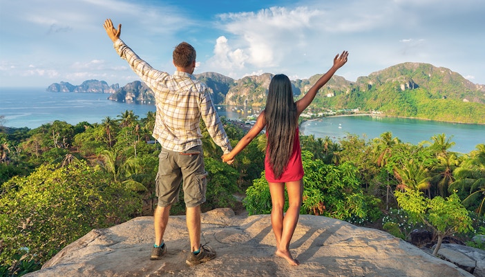Happy couple on the tropical Phi Phi island at sunset in Southern Thailand.