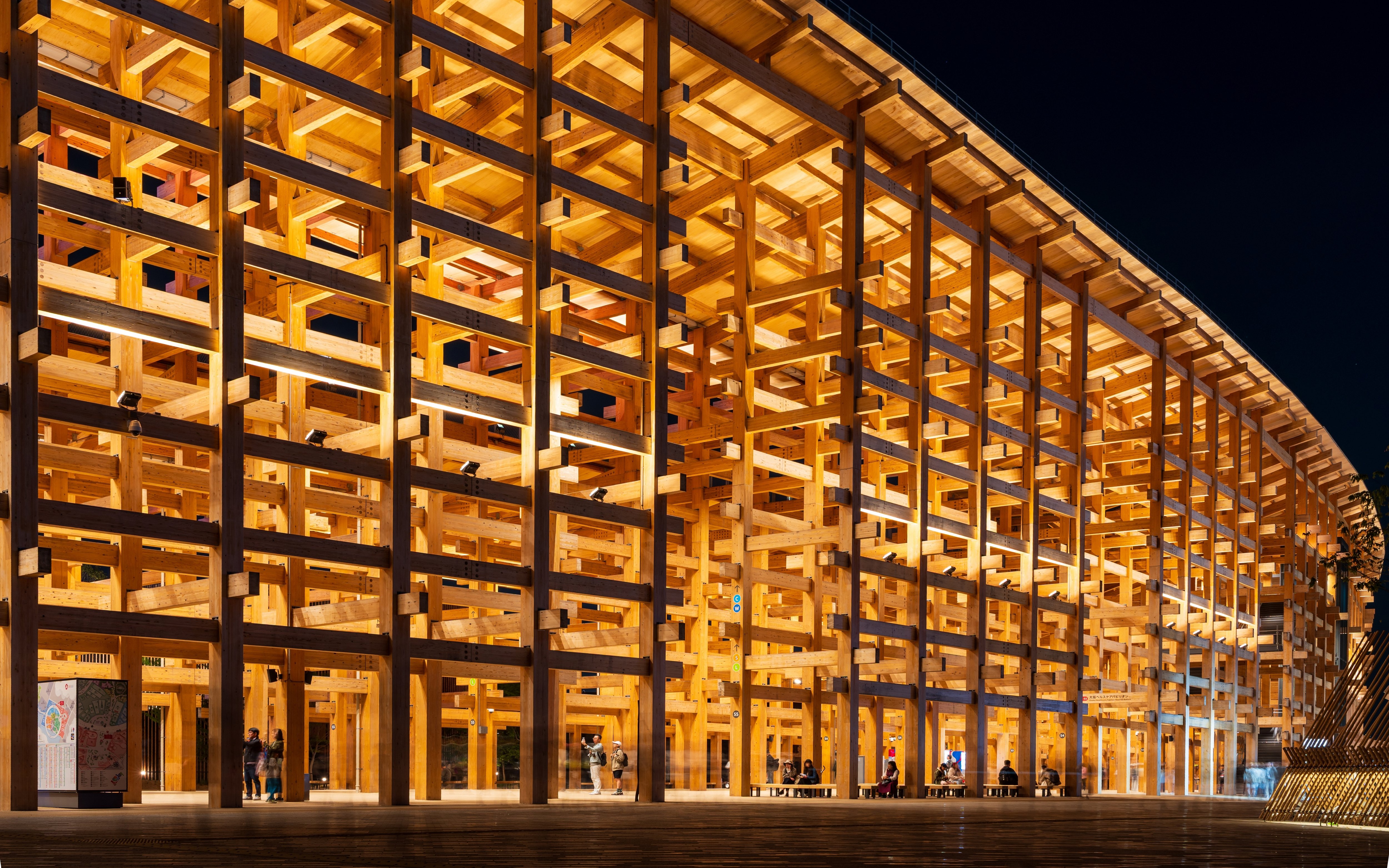 Wooden pavilion illuminated at night, Expo 2025 Osaka-Kansai, Japan.