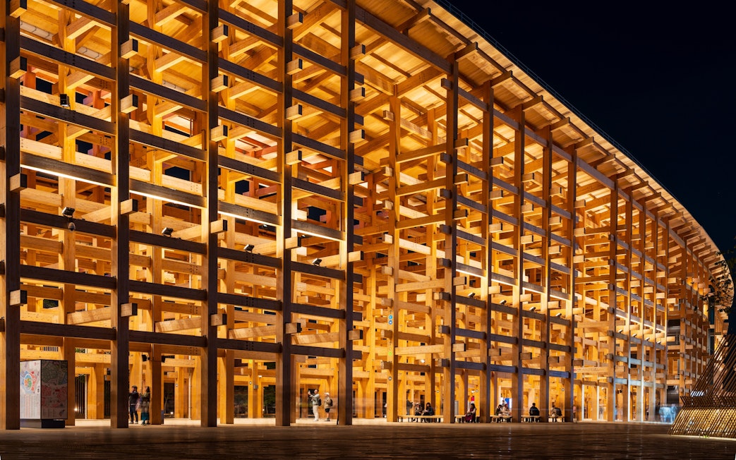 Wooden pavilion illuminated at night, Expo 2025 Osaka-Kansai, Japan.