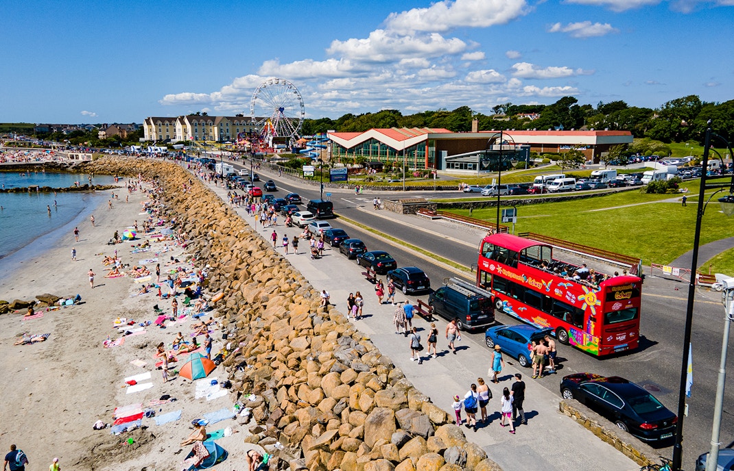 Double-decker bus on Galway Hop-On-Hop-Off Tour passing Salthill Promenade in Galway, Ireland.