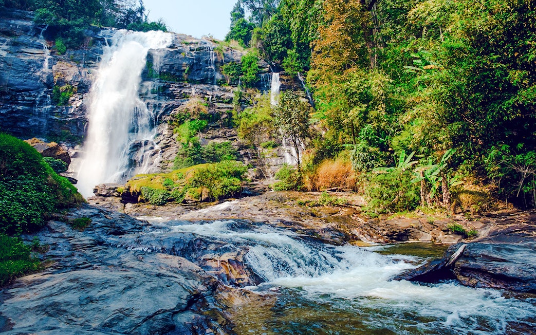 Waterfall at Doi Inthanon National Park, Chiang Mai, surrounded by lush greenery.