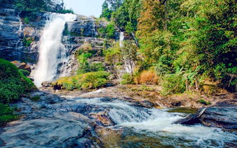 Waterfall at Doi Inthanon National Park, Chiang Mai, surrounded by lush greenery.