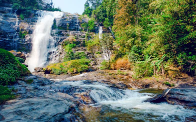 Waterfall at Doi Inthanon National Park, Chiang Mai, surrounded by lush greenery.