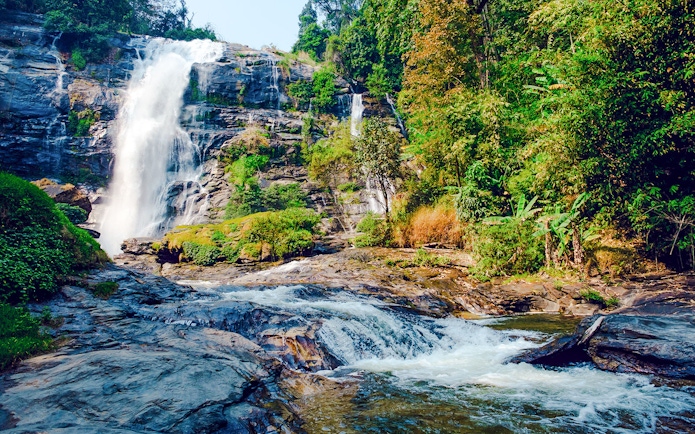 Waterfall at Doi Inthanon National Park, Chiang Mai, surrounded by lush greenery.