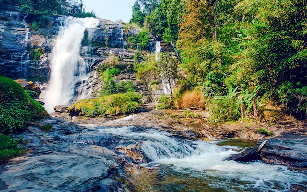 Waterfall at Doi Inthanon National Park, Chiang Mai, surrounded by lush greenery.