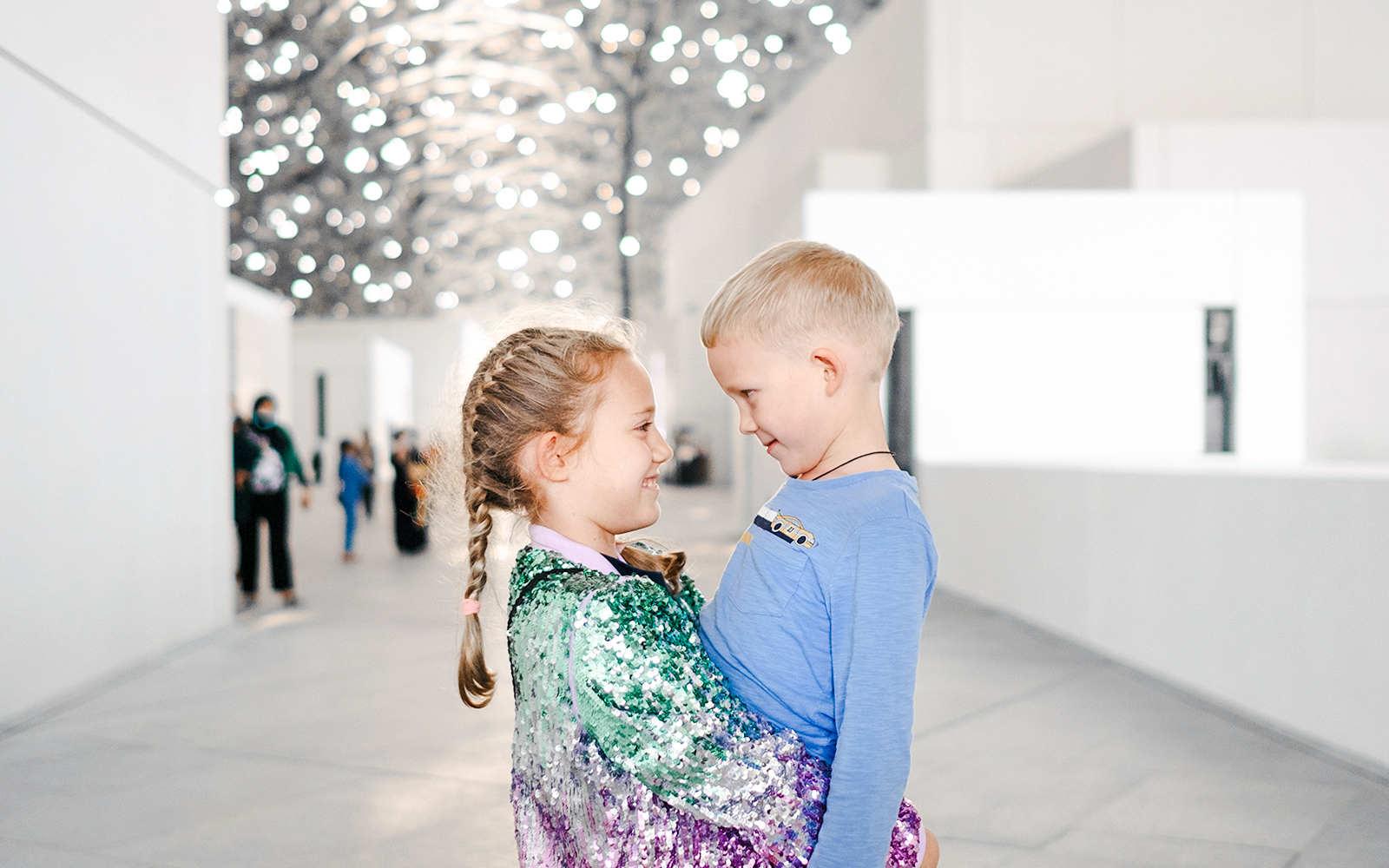 Children smiling under the Louvre Abu Dhabi's dome.