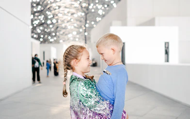 Children smiling under the Louvre Abu Dhabi's dome.