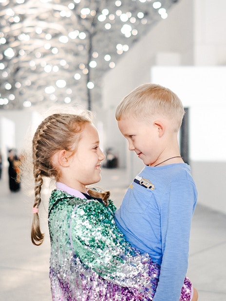 Children smiling under the Louvre Abu Dhabi's dome.