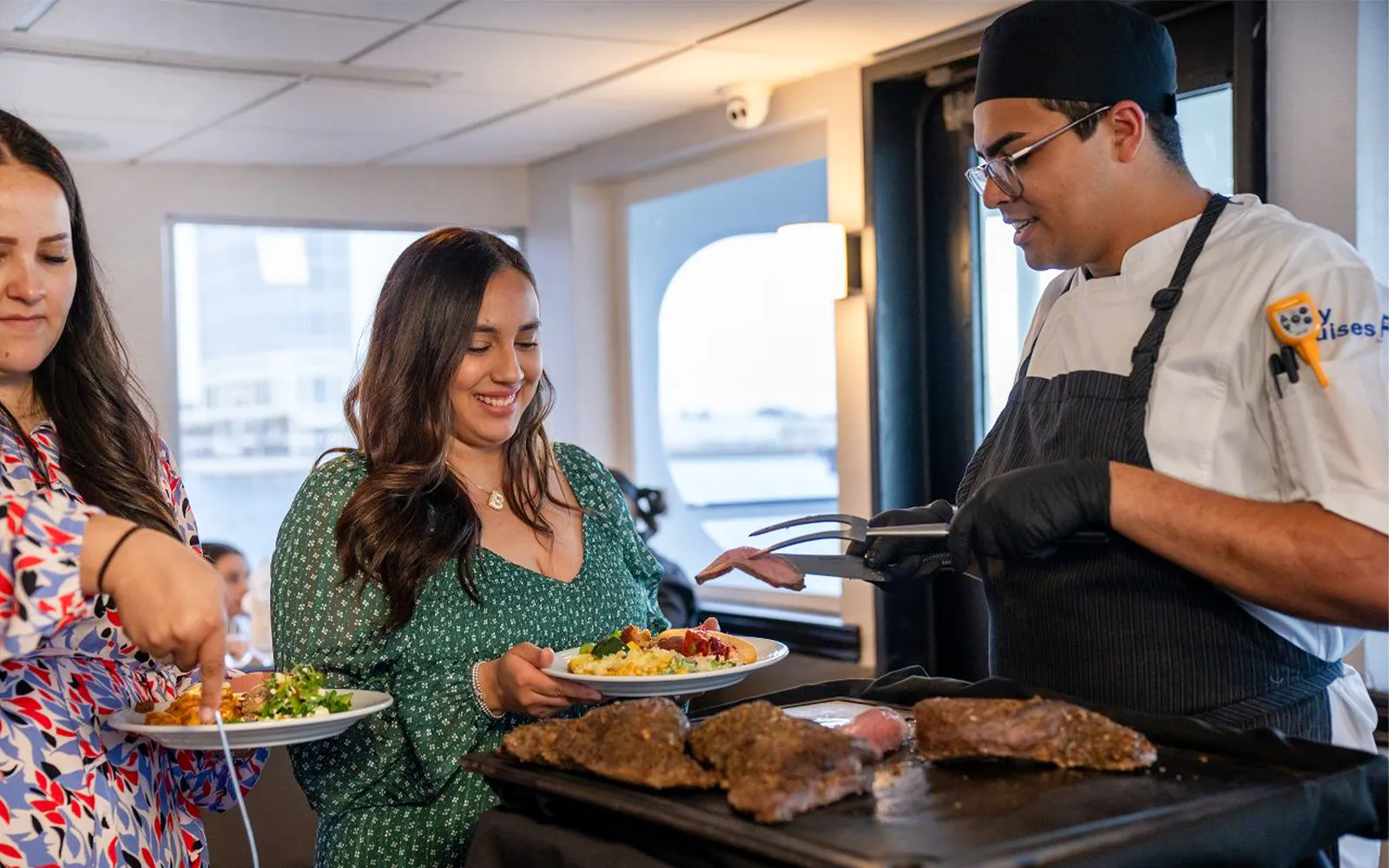 Guests being served fresh food by a chef on the San Diego Signature Dinner Cruise.