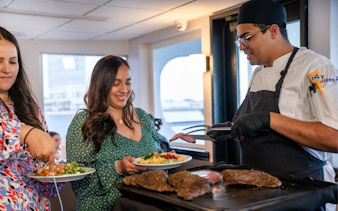 Guests being served fresh food by a chef on the San Diego Signature Dinner Cruise.