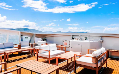 Outdoor seating area on a boat deck during ZigZag Whitsundays Day Tour.