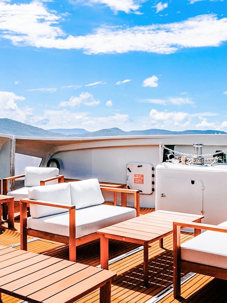 Outdoor seating area on a boat deck during ZigZag Whitsundays Day Tour.