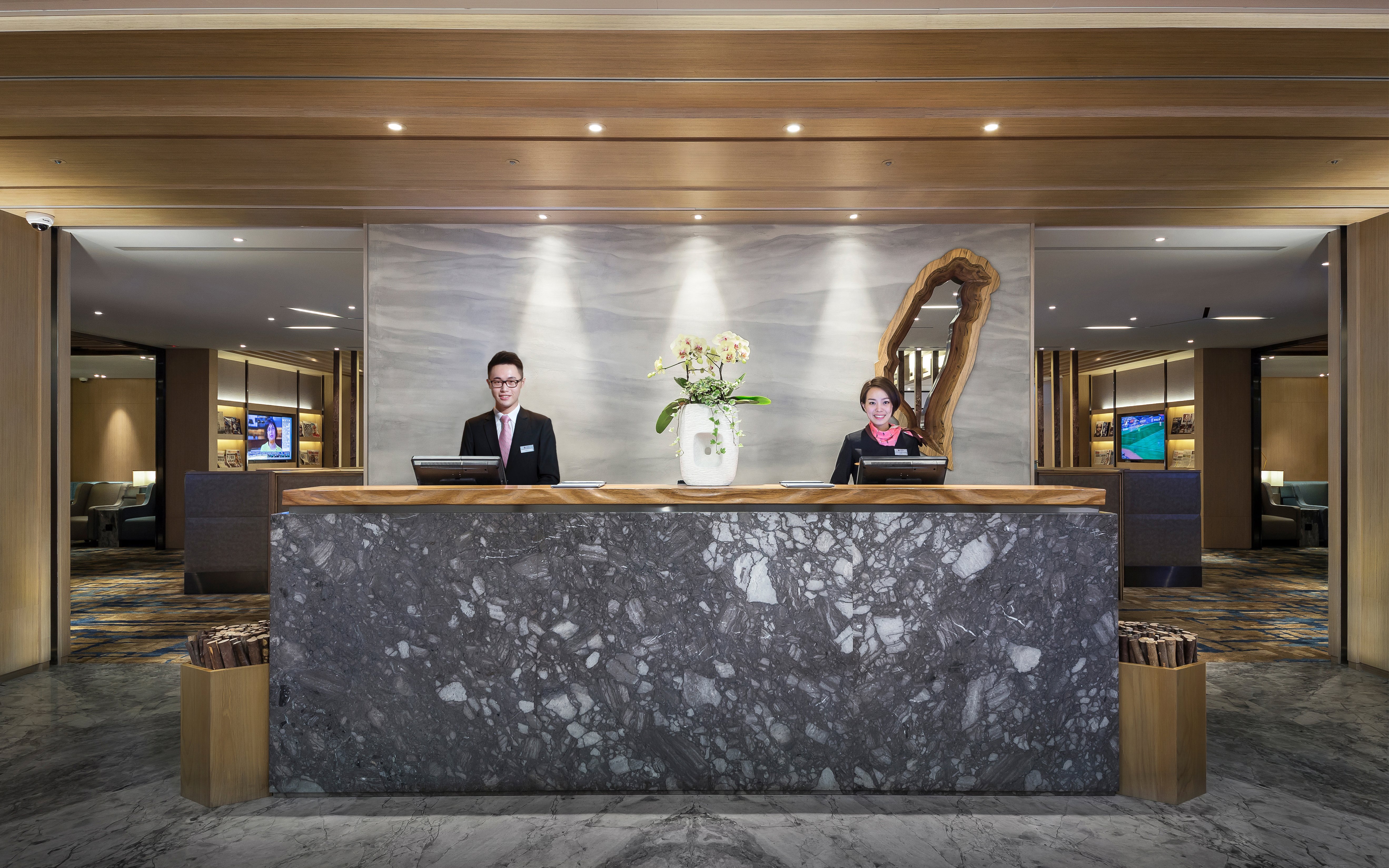 Reception desk at Plaza Premium Lounge, Zone D, Taipei, Taiwan with staff ready to assist.