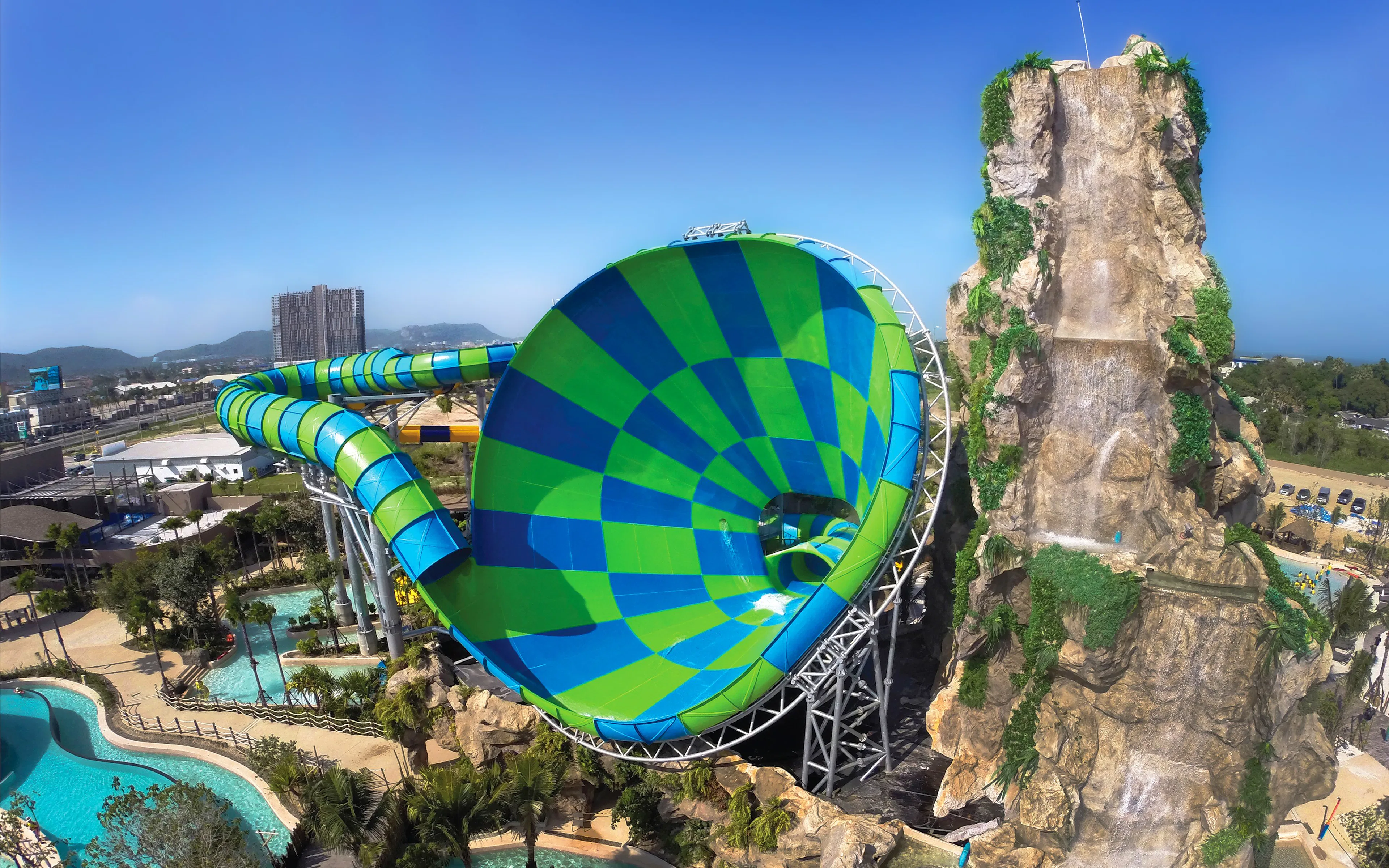Colorful water slide and rock waterfall at Vana Nava Water Jungle, Hua Hin, Thailand.