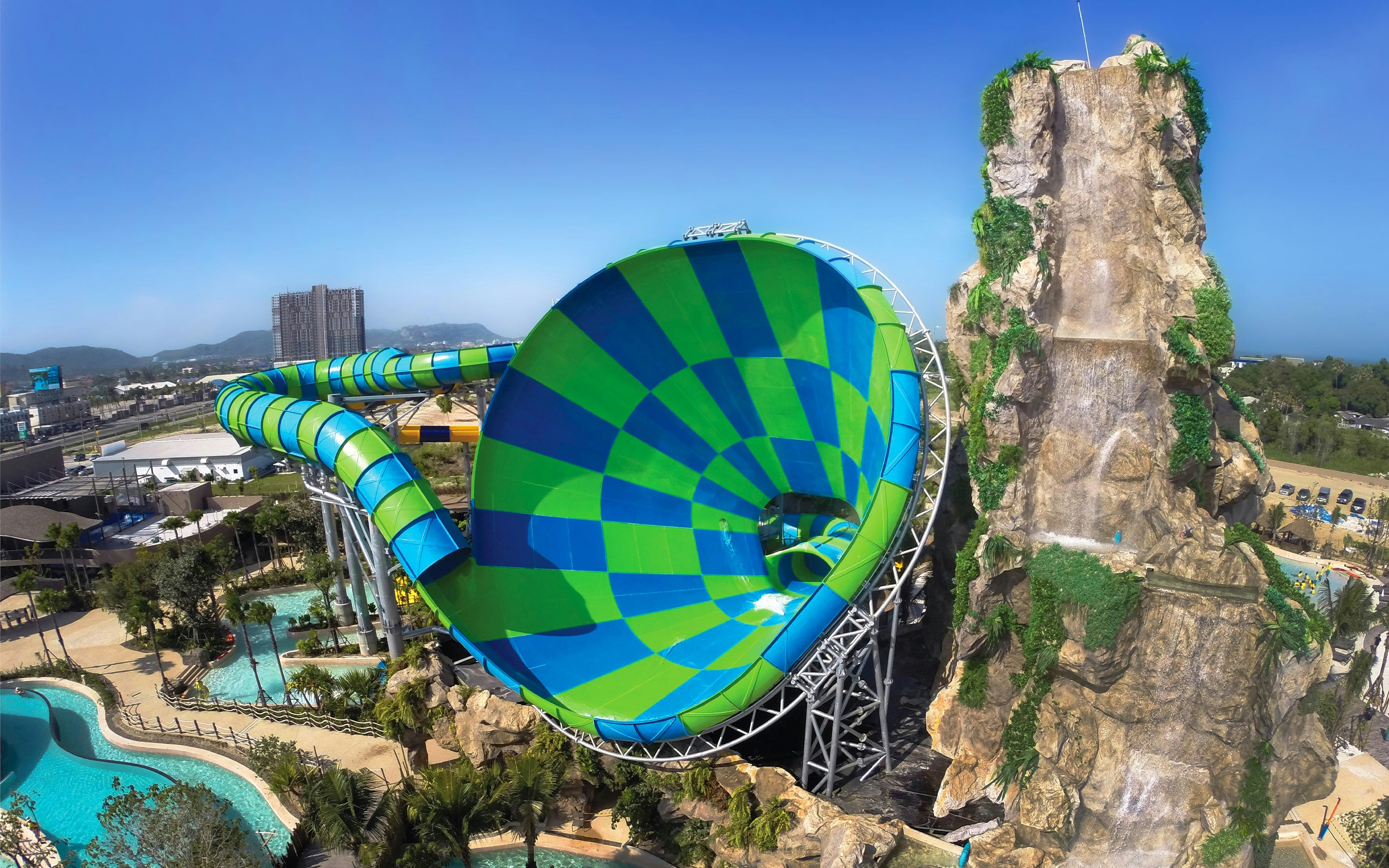 Colorful water slide and rock waterfall at Vana Nava Water Jungle, Hua Hin, Thailand.
