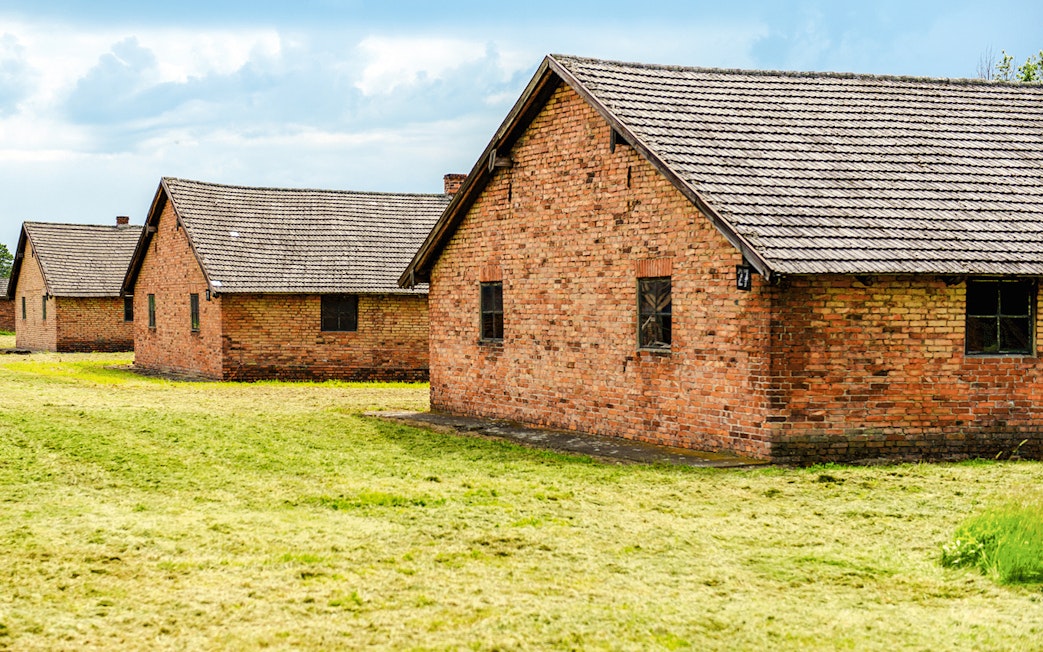 Auschwitz II barracks with brick buildings on a guided tour.
