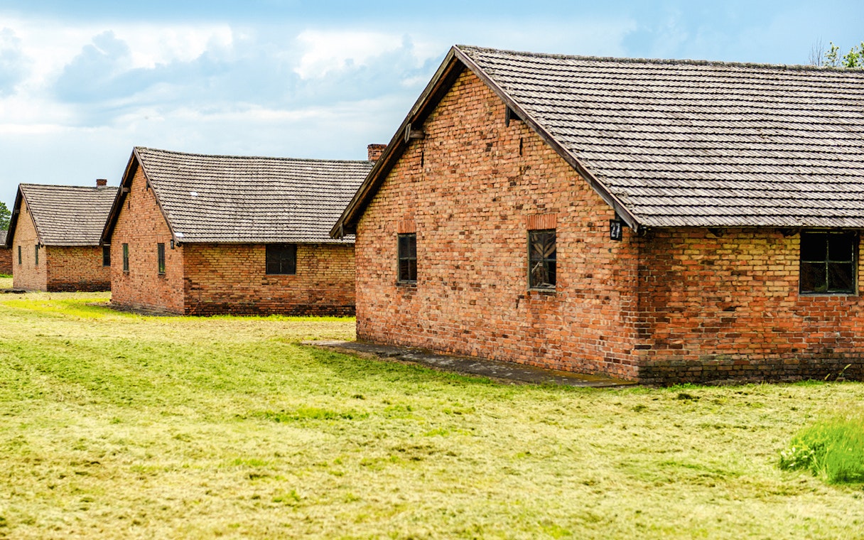 Auschwitz II barracks with brick buildings on a guided tour.