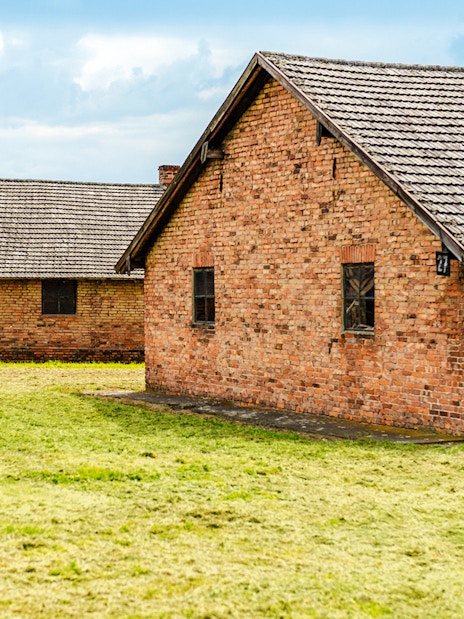 Auschwitz II barracks with brick buildings on a guided tour.