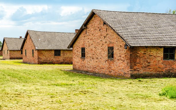 Auschwitz II barracks with brick buildings on a guided tour.