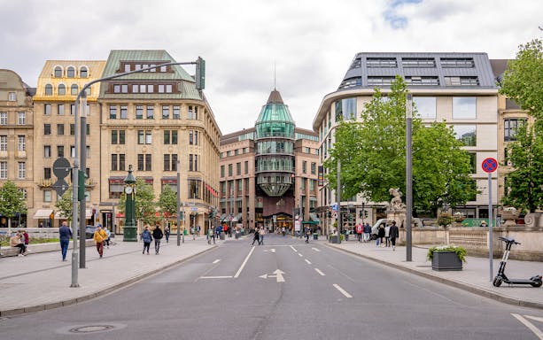 Konigsallee street view in Dusseldorf with historic buildings and pedestrians.
