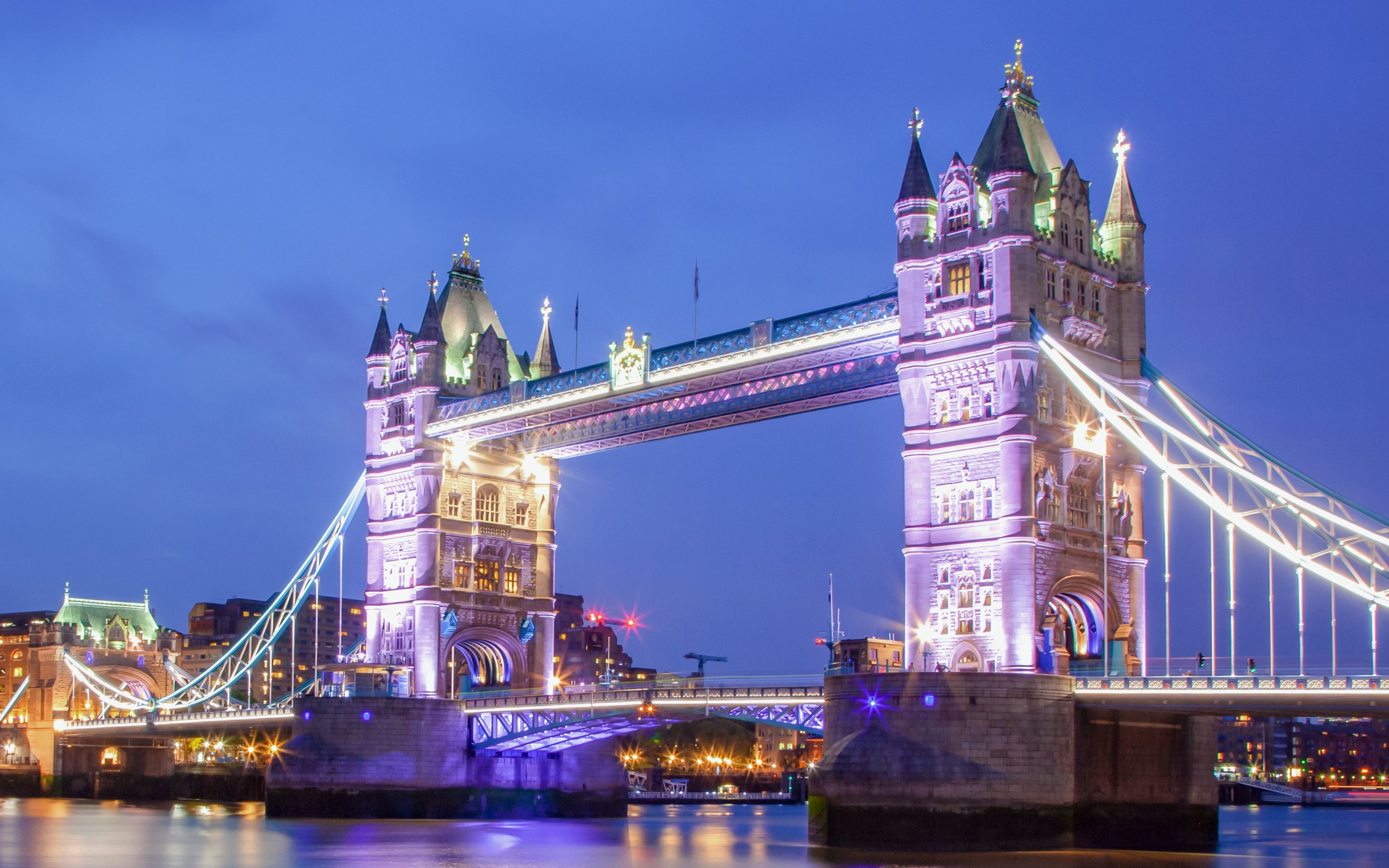 Tower Bridge illuminated at night over the River Thames, London, UK.