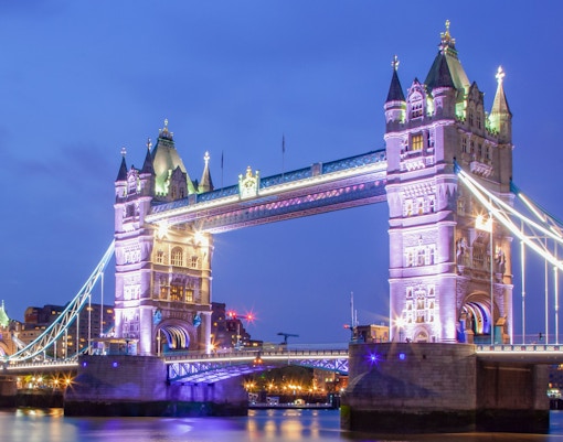 Tower Bridge illuminated at night over the River Thames, London, UK.