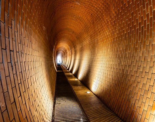 Deer Moat pedestrian tunnel in Prague with historic stone walls.