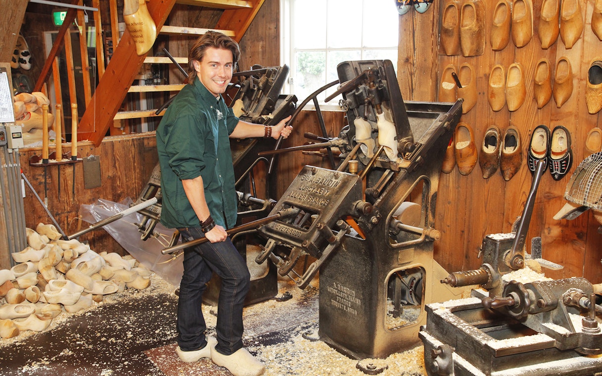 Man operating shoemaking machine during Keukenhof guided tour.