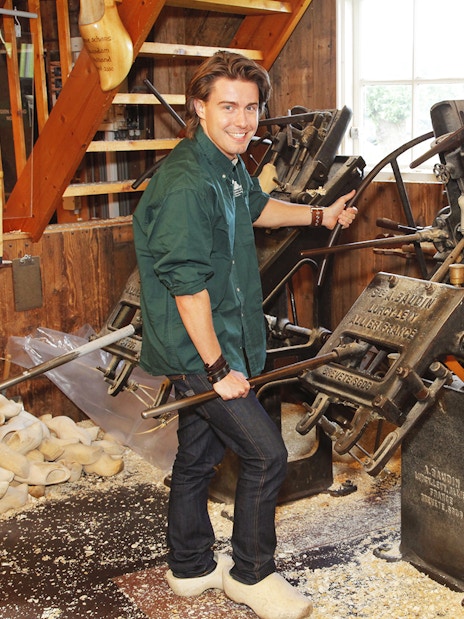 Man operating shoemaking machine during Keukenhof guided tour.