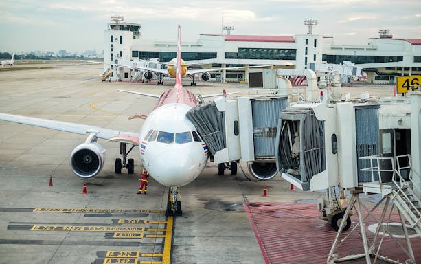 Airplane at gate with jet bridge at Don Mueang Airport, Bangkok.