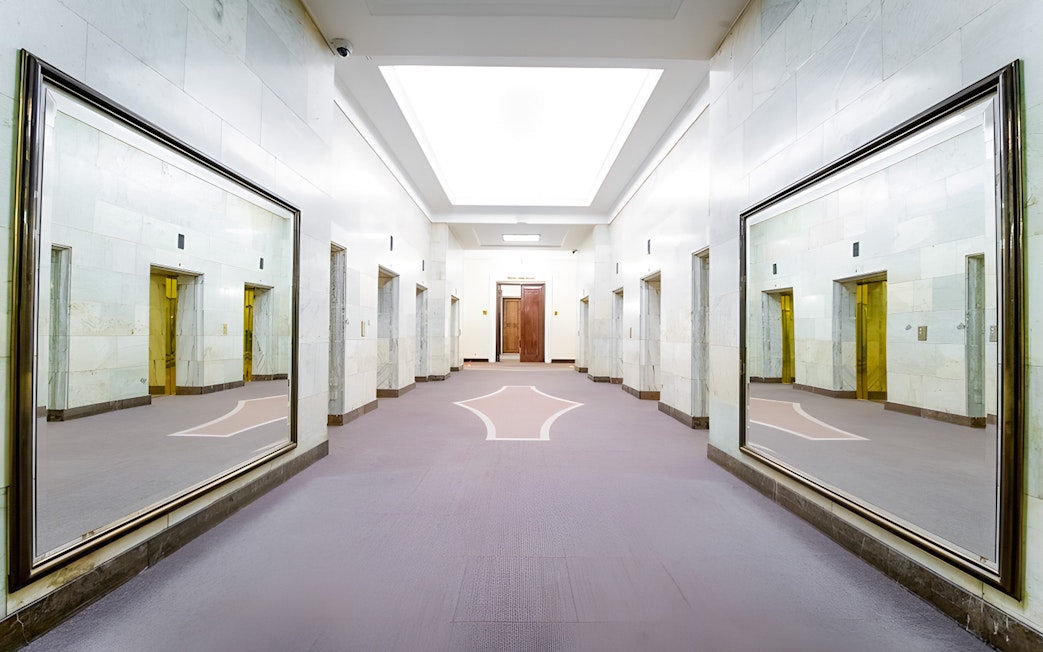 Elevator lobby inside Palace of Culture and Science, Warsaw, with mirrored walls.