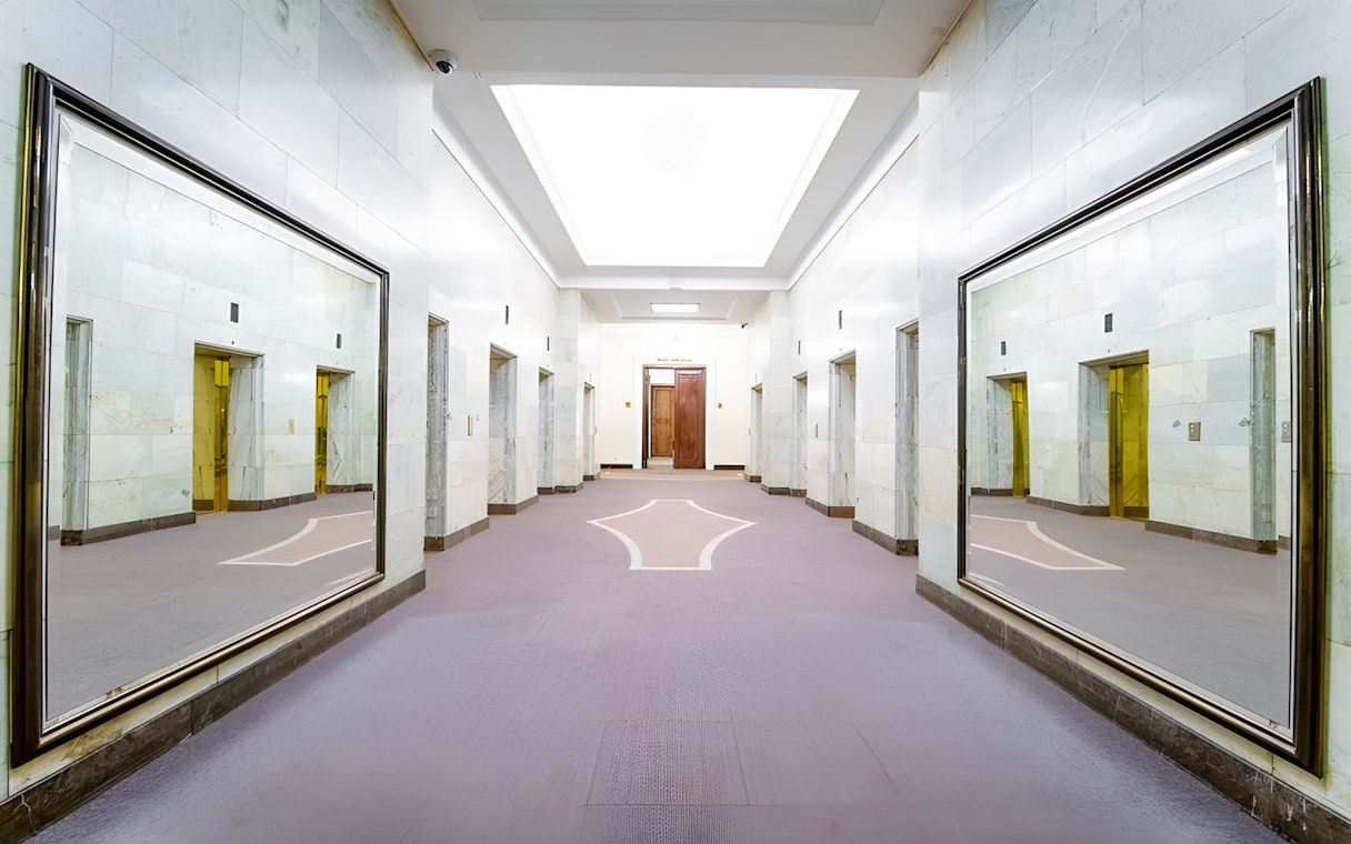 Elevator lobby inside Palace of Culture and Science, Warsaw, with mirrored walls.