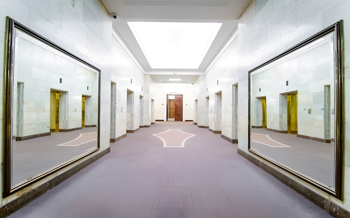 Elevator lobby inside Palace of Culture and Science, Warsaw, with mirrored walls.